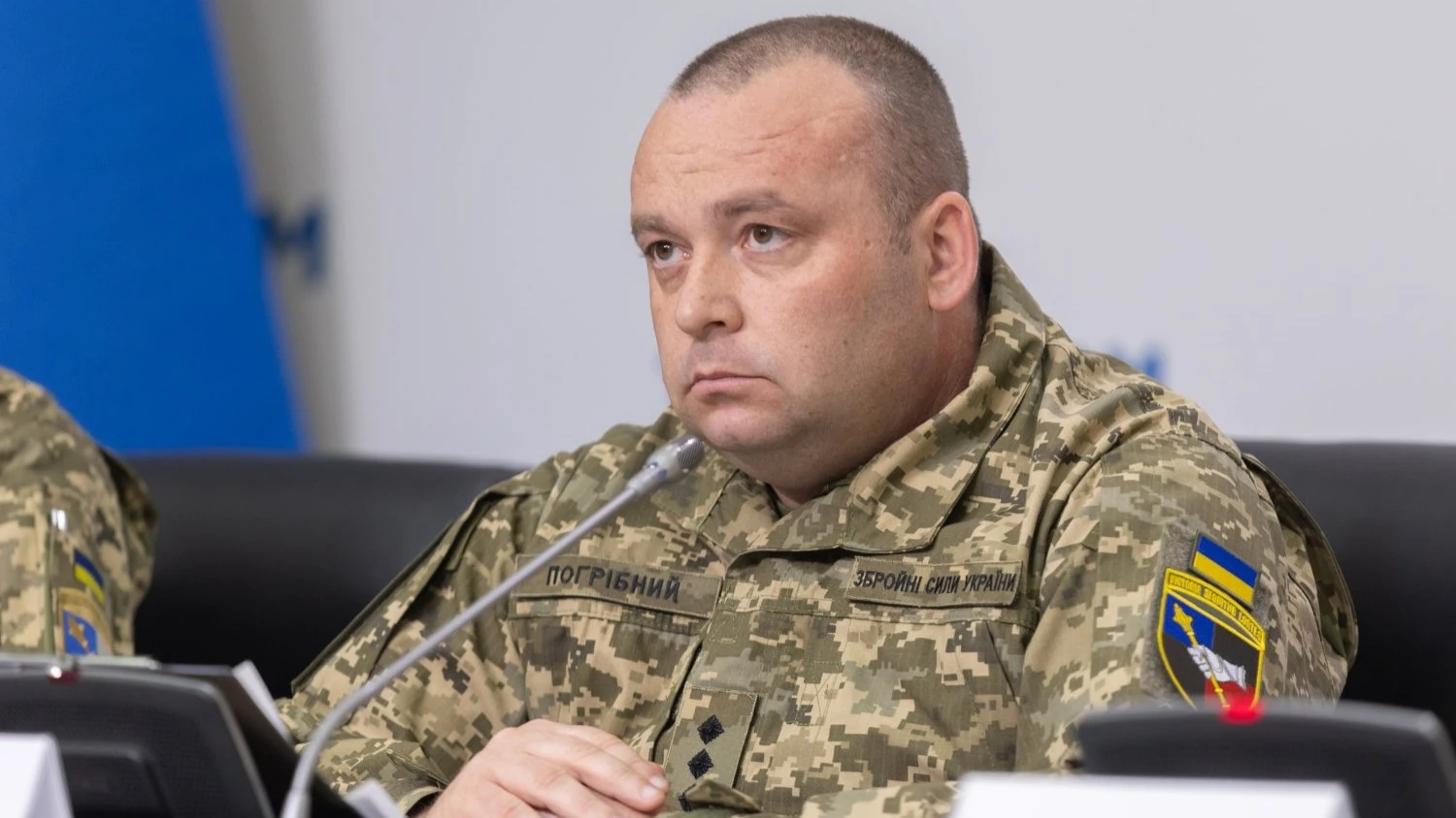 Юрій Погрібний на тлі військової форми Збройних Сил України