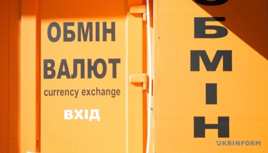 Банкноти долара та євро поруч із графіком курсу гривні