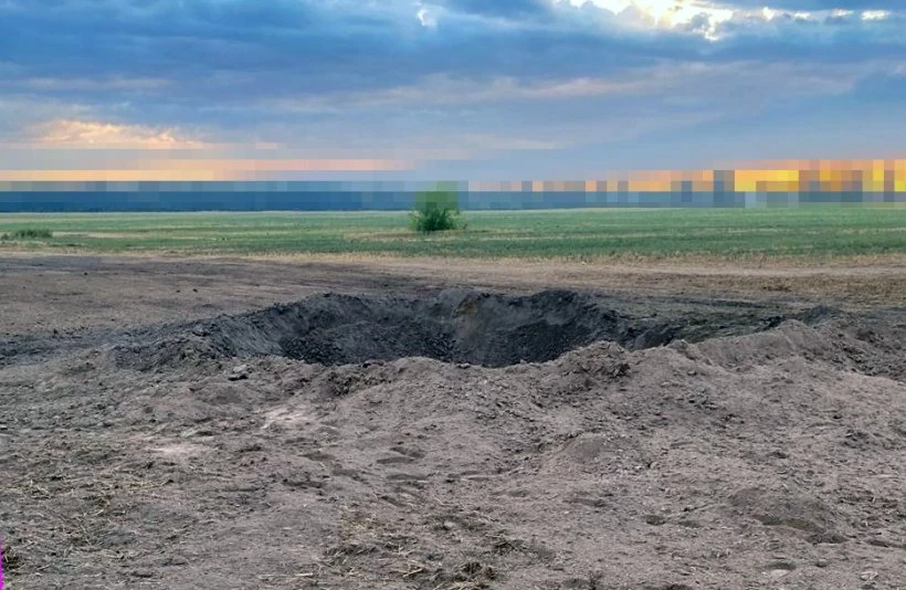 Уламок крилатої ракети зі слідами від куль та вирва в полі на місці падіння (фото ДПСУ)